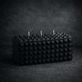 Matte black geometric three wick soy candle with pyramid texture.