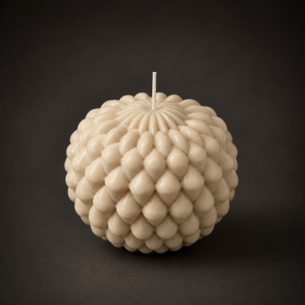 Obsidian Bloom sculptural candle in Cashmere, featuring a layered petal-inspired form in warm oat-toned wax. Photographed against a dark backdrop to emphasise the candle’s texture, subtle colour variation and handcrafted detail.
