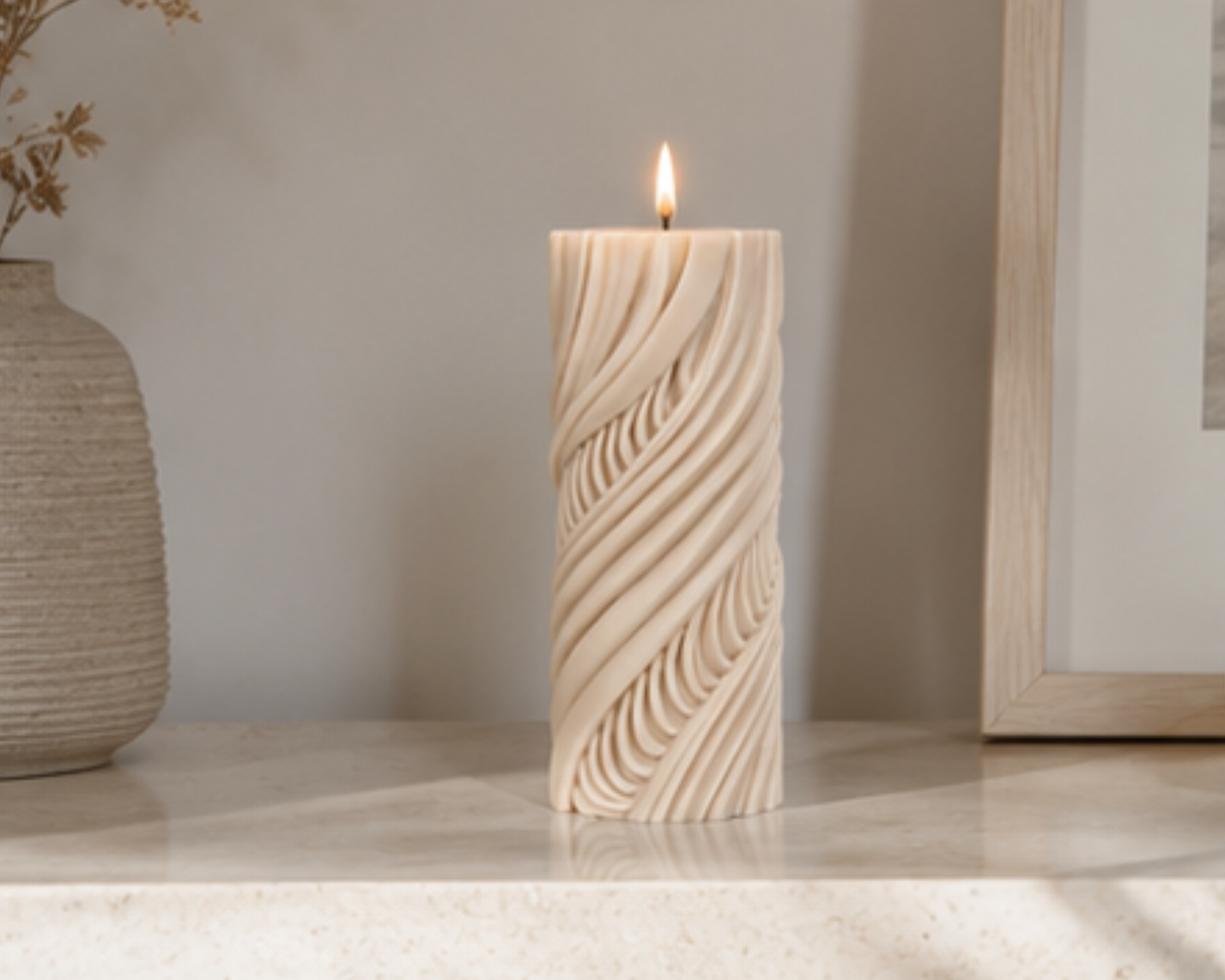 Lit Cashmere Obsidian Current sculptural candle on a marble console surrounded by neutral décor and soft afternoon light.