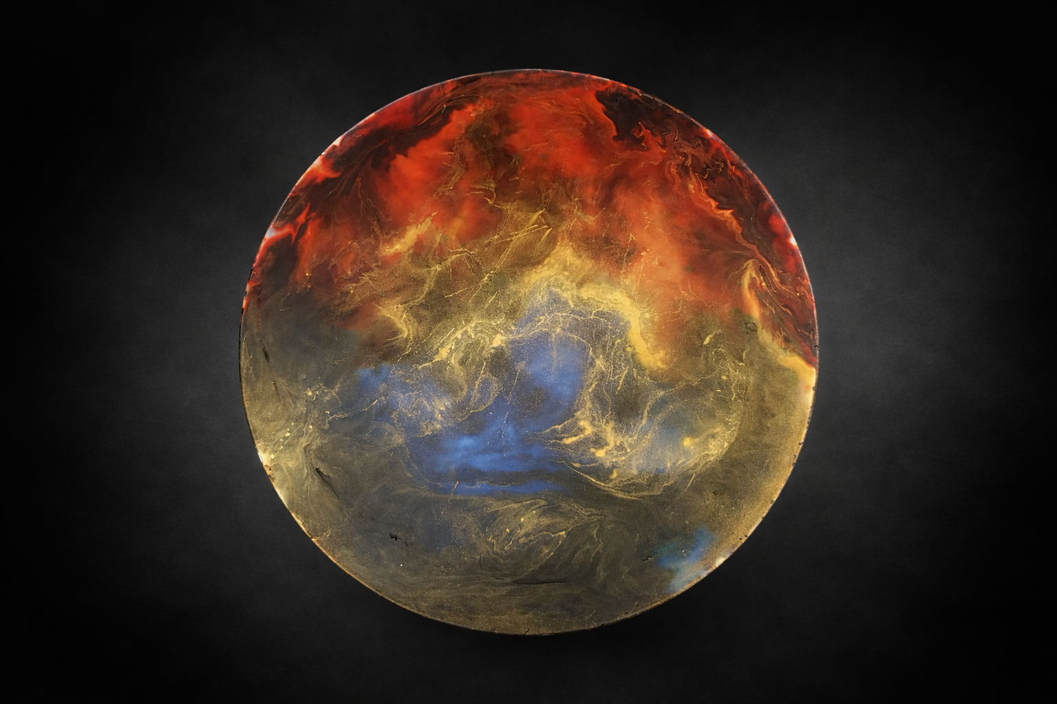 Handcrafted circular wax art featuring molten red, gold and blue swirls resembling a glowing planet or solar storm, abstract encaustic style.