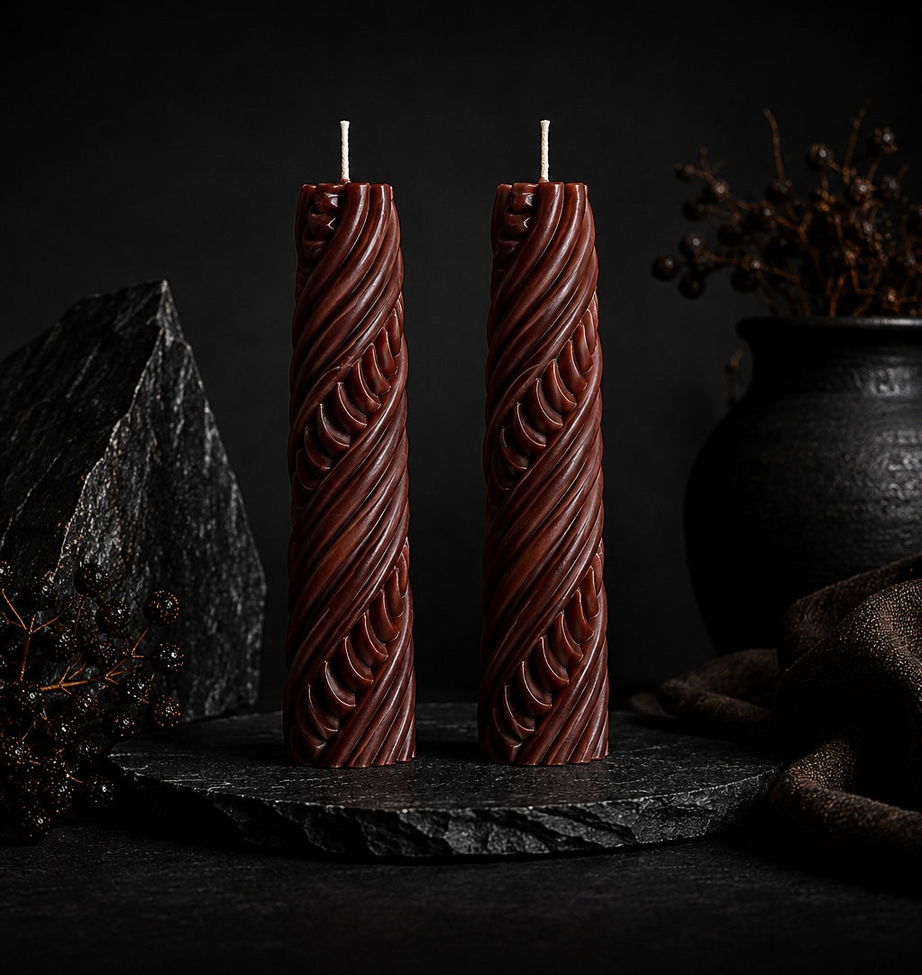 Pair of Obsidian Twist sculptural candles in Ember red displayed together.