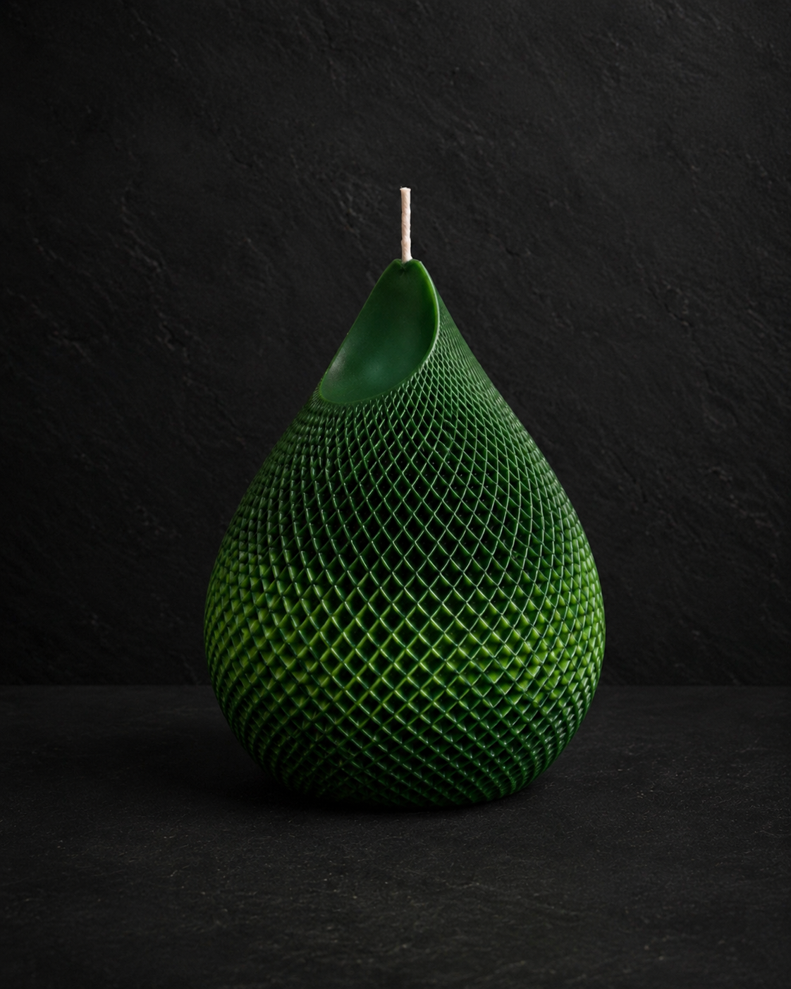 Emerald Veil textured sculptural candle with layered forest green tones against a charcoal editorial background.