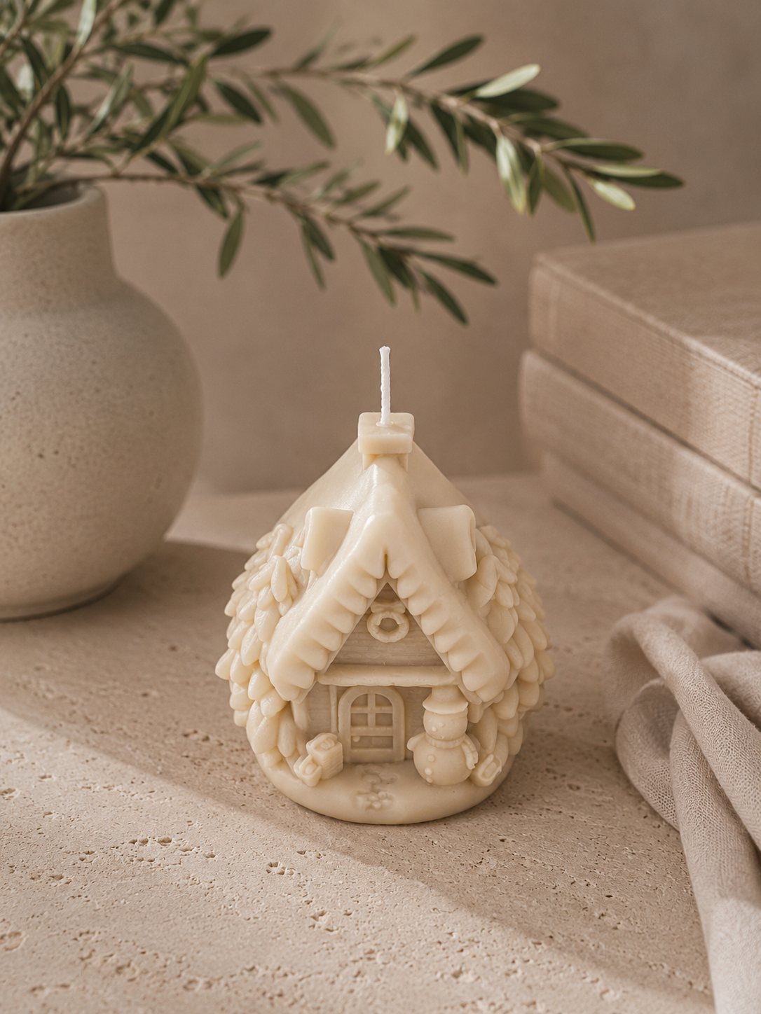 Glow Pantry Flocked Tree Cabin candle in Cashmere, a hand-poured sculptural Christmas tree cabin candle styled on a natural timber slice.