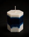 Midnight Hex geometric sculptural candle with layered white and deep midnight blue tones against a charcoal editorial background.