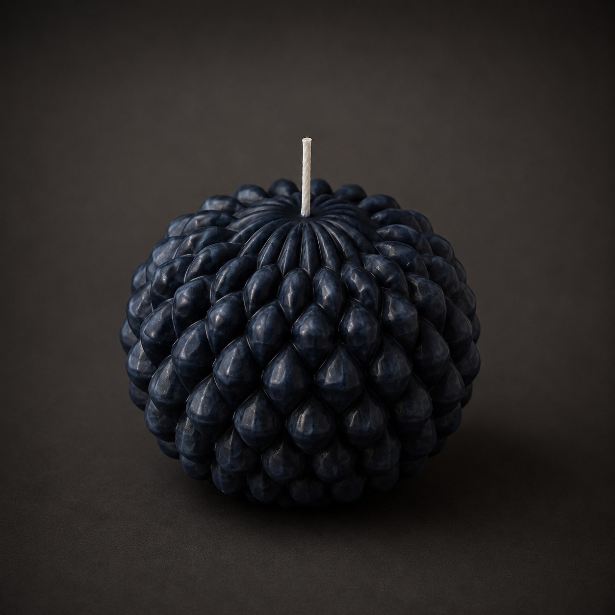 Obsidian Bloom sculptural candle in Midnight, featuring a layered petal-inspired form in deep charcoal-blue wax. Photographed against a dark backdrop to emphasise the candle’s texture, colour depth and handcrafted detail.