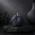 Obsidian Sphere sculptural candle in deep midnight blue displayed on a charcoal stone plinth against a dark editorial backdrop.