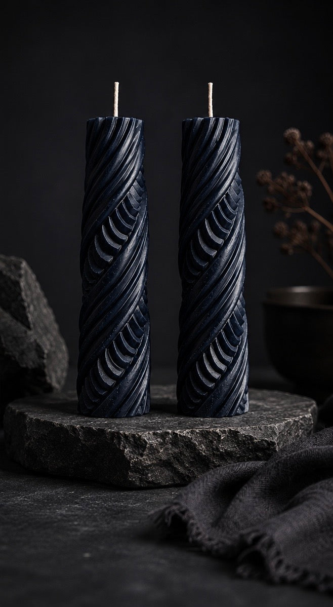Pair of Obsidian Twist sculptural candles in Midnight storm blue featuring carved ribbon texture from the Lowlight Series.