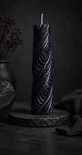 Obsidian Twist sculptural candle in Midnight deep blue featuring carved ribbon texture.