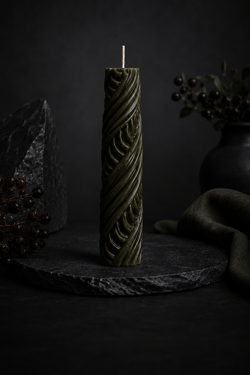 Obsidian Twist sculptural candle in Moss green featuring carved ribbon detailing.