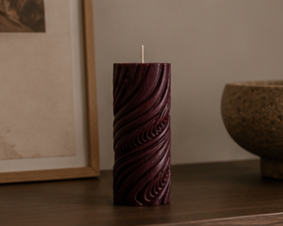 Mulberry Obsidian Current sculptural pillar candle styled on a timber console with neutral artwork, textured ceramics and warm contemporary home décor.