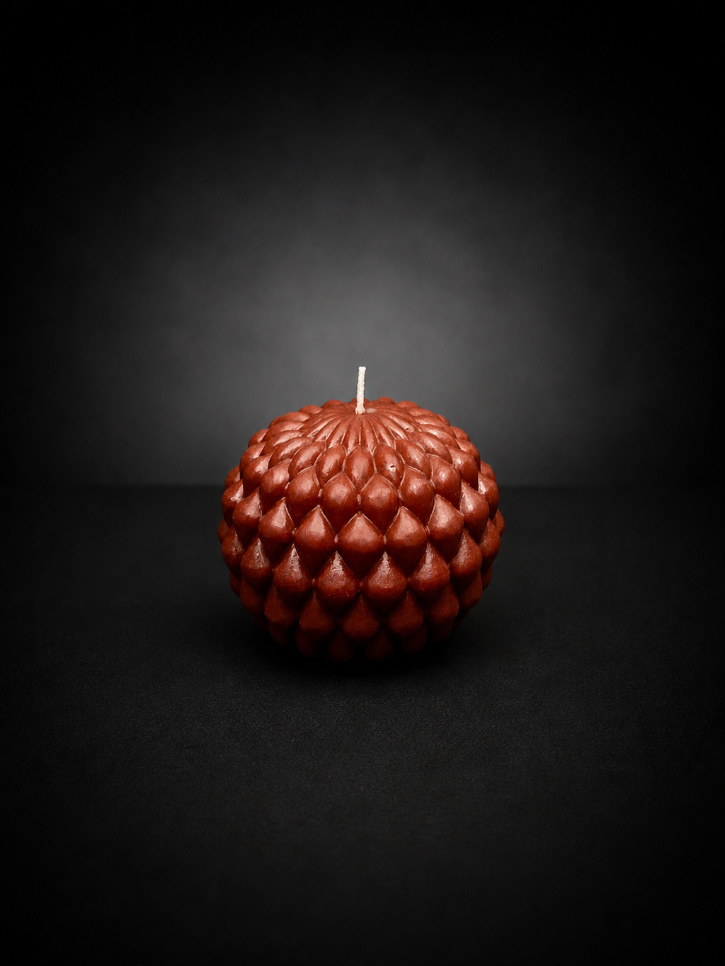 Ember Obsidian Bloom sculptural candle with layered petal texture on a dark, lowlight background