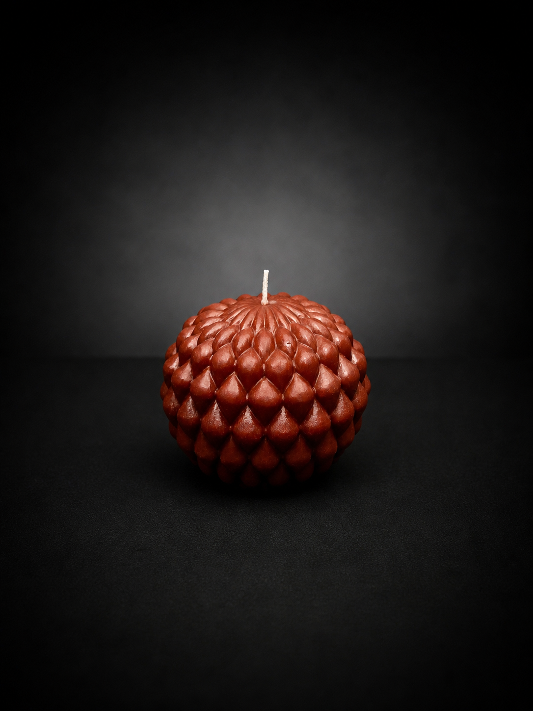 Ember Obsidian Bloom sculptural candle with layered petal texture on a dark, lowlight background