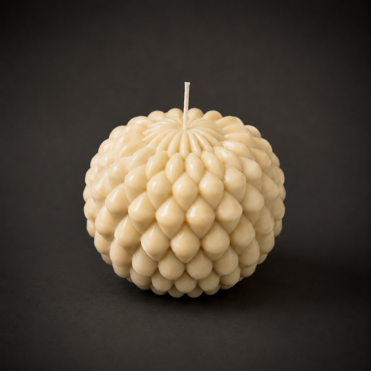 Obsidian Bloom sculptural candle in Parchment, featuring a layered petal-inspired form in soft ivory wax. Photographed against a dark backdrop to emphasise the candle’s texture, gentle colour variation and handcrafted detail.
