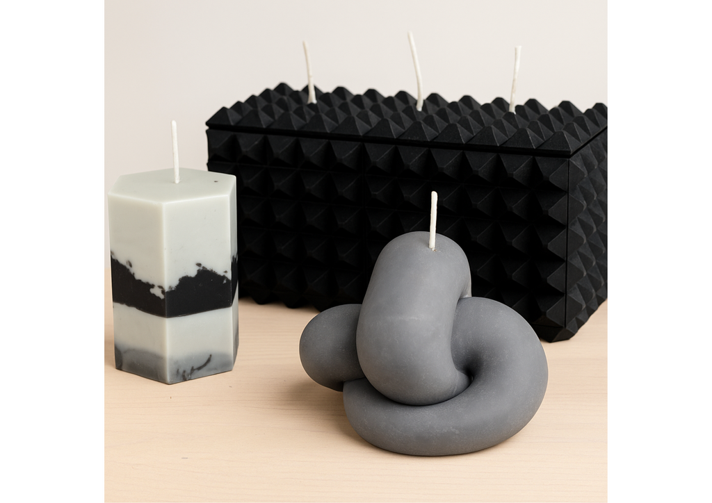 The Gordian Knot sculptural candle displayed alongside geometric black sculptural candles in a curated editorial arrangement.