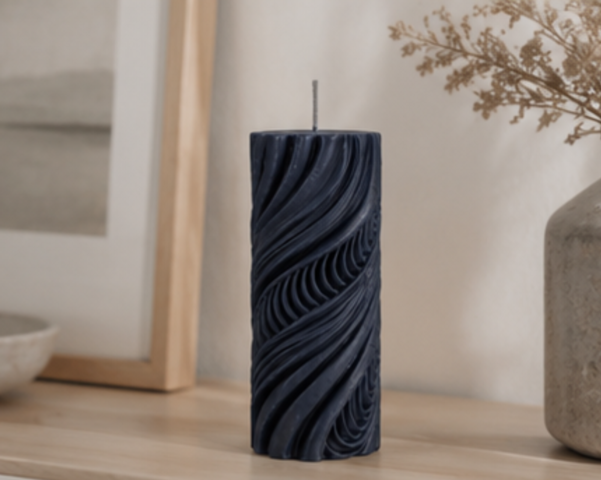 Midnight Obsidian Current sculptural pillar candle styled on a light timber console with neutral ceramics and framed artwork.