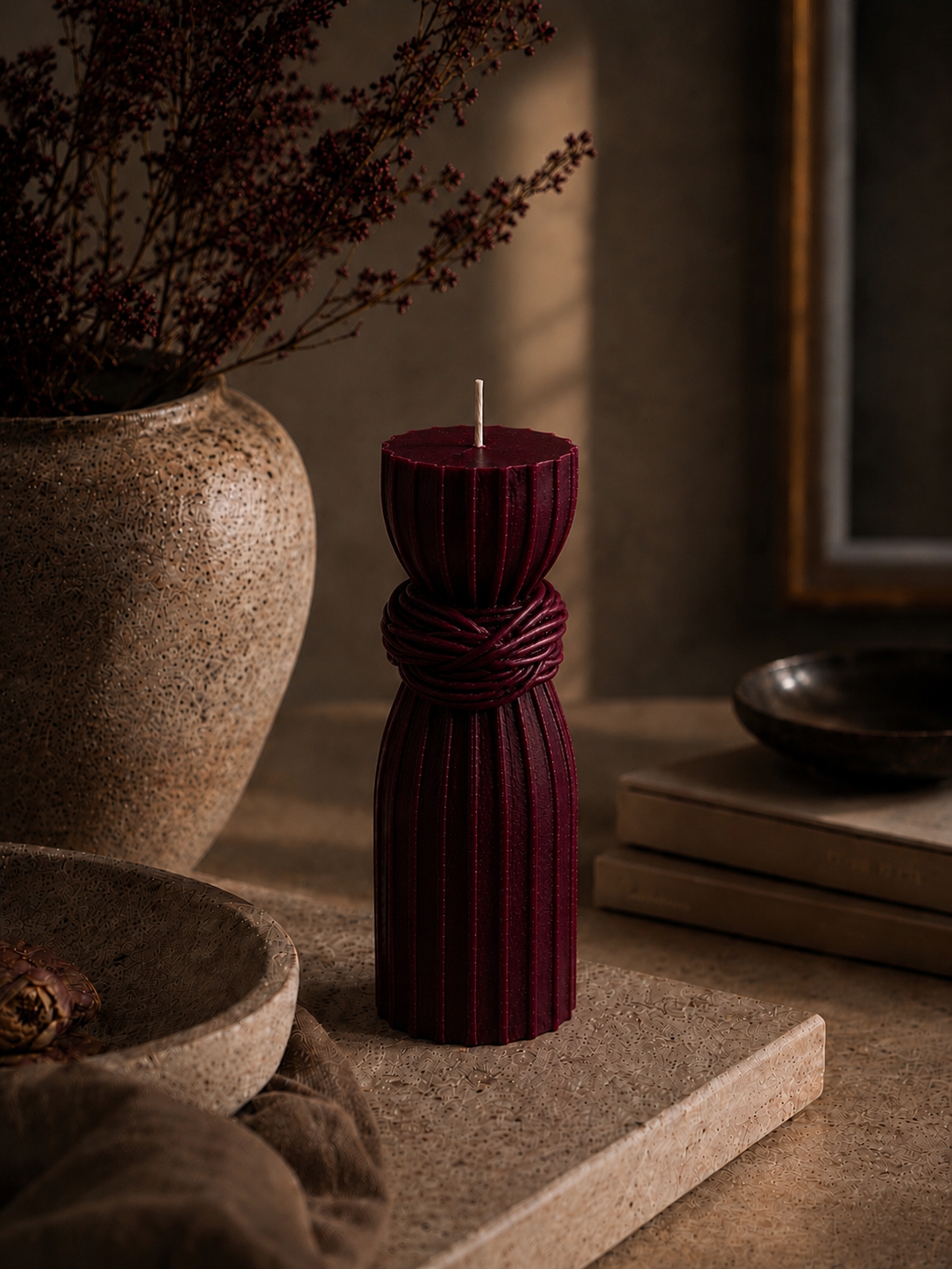 Glow Pantry deep mulberry sculptural pillar candle in a luxury lifestyle setting with travertine stone, ceramic décor and warm ambient lighting.